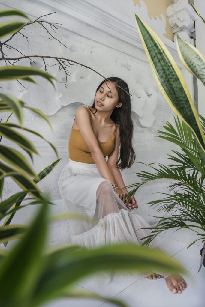 girl dressed in all white sitting with plants